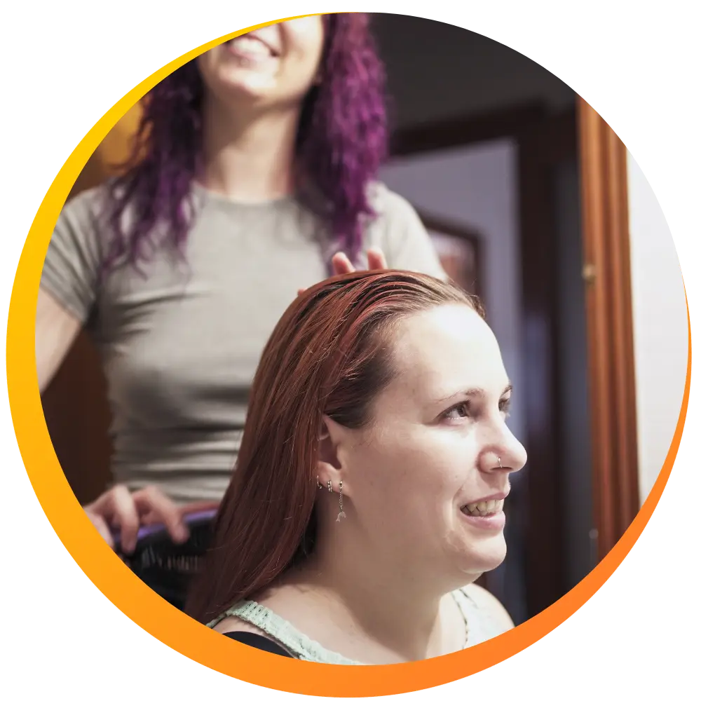 A support worker brushing another woman's hair